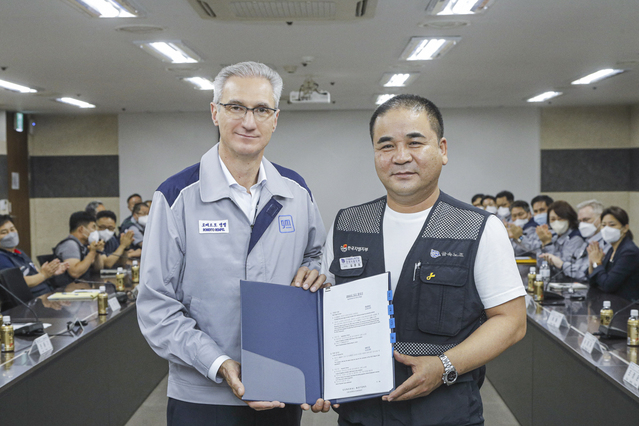 ▲ 금속노조 한국지엠지부 김준오 지부장과 로베르토 렘펠 한국지엠 사장이 악수하고 있다 ⓒ한국지엠