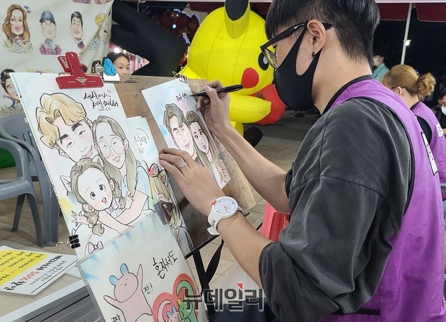 ▲ 천안흥타령춤축제 행사장 부스에 마련된 캐리커처가 인기다. 한 화가가 시민의 얼굴을 보며 캐리커처를 그리고 있다.ⓒ뉴데일리 D/B