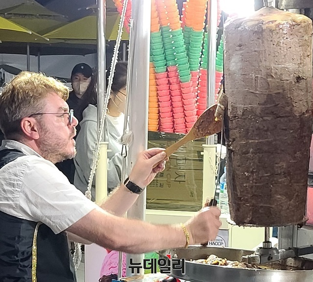 ▲ 천안흥타령춤축제 구경도 식후경. 한 튀르키예인이 지난 22일 천안종합운동장에 마련된 축제장에서 양고기케밥을 자르고 있다.ⓒ뉴데일리 D/B