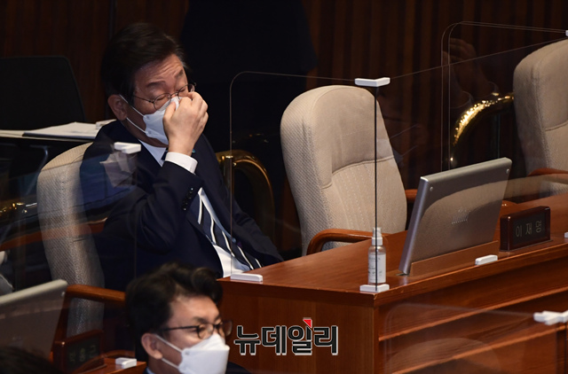 ▲ 이재명 더불어민주당 대표가 지난 29일 오전 국회에서 열린 본회의에 참석해 정진석 국민의힘 비상대책위원장의 교섭단체 대표연설을 들으며 마스크를 고쳐쓰고 있다. ⓒ뉴데일리(사진=공동취재단)
