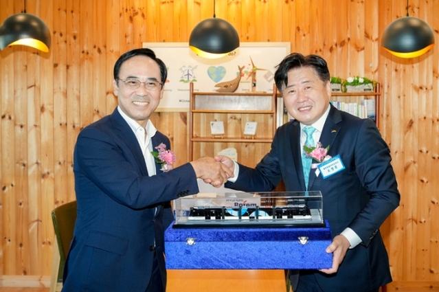 ▲ 오영훈 제주도지사(사진에서 오른쪽)와 이용배 현대로템 사장이 현대로템 수소전기트램 모형을 들고 기념촬영을 하고 있다.ⓒ현대로템