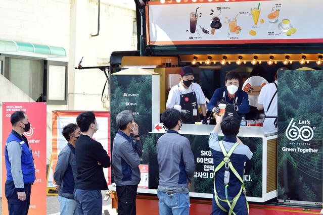 ▲ 4일 인천 서구 SK인천석유화학에서 GO 해피트럭의 일일 바리스타로 나선 최윤석 사장(해피트럭 내부 가운데)이 협력사 구성원들에게 감사의 의미를 담아 음료를 전달하고 있다. ⓒSK이노베이션 제공