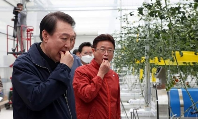 ▲ 윤석열 대통령(왼쪽)과 이철우 도지사가 5일 상주 스마트팜 현장에서 열린 비상경제민생회의에 참석해 농산물을 직접 먹어보고 있다.ⓒ이철우 지사 페이스북 캡처