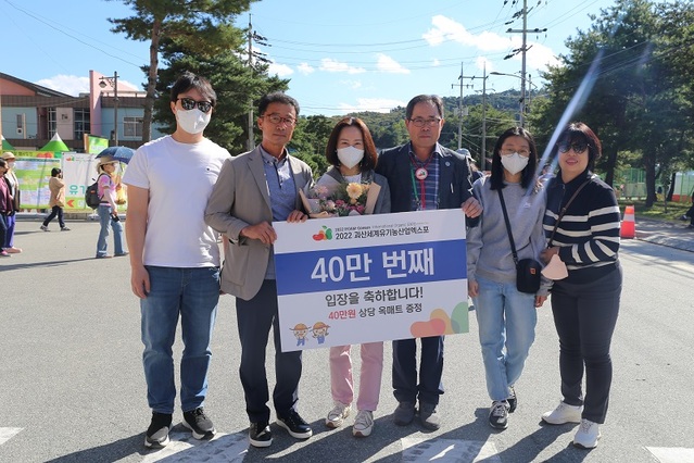 ▲ 괴산유기농엑스포가 개장 9일째를 맞아 40만명째 입장객을 돌파했다. 사진은 엑스포 조직위 관계자가 경기도 화성시 거주 이윤주 씨 가족에게 꽃다발과 선물을 전달하고 있다.ⓒ괴산유기농엑스포 조직위
