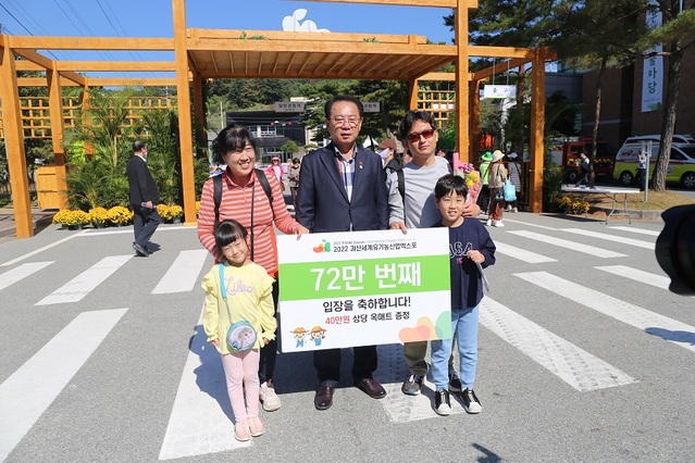 ▲ 송인헌 괴산군수가 지난 15일 괴산유기농엑스포장에서 72만번째 입장객인 이영훈 씨 가족에게 선물을 전달하면서 기념촬영을 하고 있다. ⓒ괴산유기농엑스포 조직위