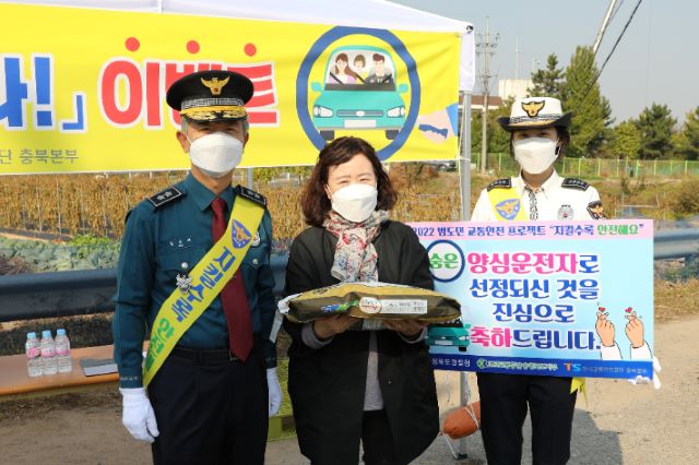 ▲ 충북경찰청이 27일 청주권 3개소에서 ‘양심 운전자를 찾아라!’ 이벤트를 개최한 가운데 양심운전자로 선정된 한 운전자가 김교태 청장으로부터 현장에서 선물로 햅쌀 10kg 들이 1포대를 증정받고 기념사진을 찍고 있다.ⓒ충북경찰청