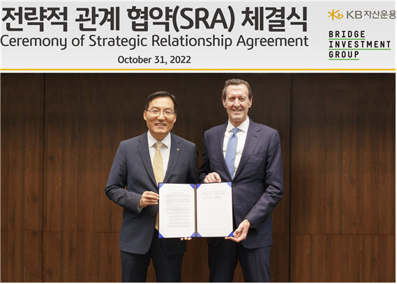 ▲ 브릿지투자그룹 회장 로버트 모스(Robert Morse)와 KB자산운용의 이현승대표가 전략적 관계협약(SRA)를 체결한 뒤 사진촬영을 하고 있다. ⓒKB자산운용