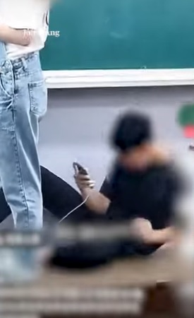 ▲ 지난 8월 26일 충남 홍성의 한 중학교에서 수업 중 한 학생이 교단에 앉아 여교사 뒷모습을 촬영하는 듯한 모습이다. 이 영상은 다른 학생이 촬영해 동영상에 올리면서 확산되며 교권침해 등 파장이 일고 있다.ⓒ중앙일보 동영상 캡처