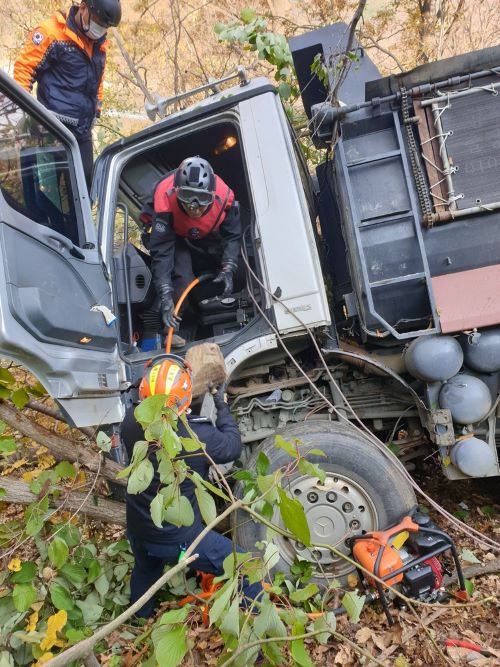▲ 7일 오전 9시41분쯤 옥천군 군북면의 한 국도에서 50대 A 씨가 운전하던 25t 트럭이 가드레일을 들이받고 40여m 아래 비탈길로 추락했다.ⓒ옥천소방서