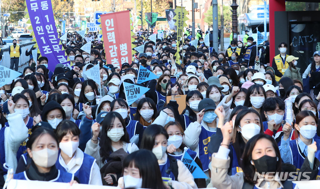 ▲ 전국민주노동조합 총연맹 공공운수노조 의료연대본부 서울대학교 분회 조합원들이 23일 오전 서울 종로구 마로니에 공원 앞에서 열린 2차파업 돌입 출정식에서 구호를 외치고 있다. ⓒ뉴시스