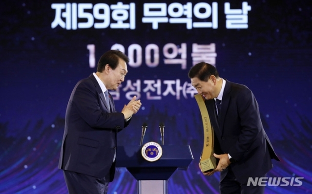 ▲ 윤석열 대통령이 5일 서울 삼성동 코엑스에서 열린 제59회 무역의날 기념식에서 삼성전자 한종희 대표이사에게 천이백억불 수출의 탑을 친수한 후 박수를 보내고 있다. ⓒ뉴시스