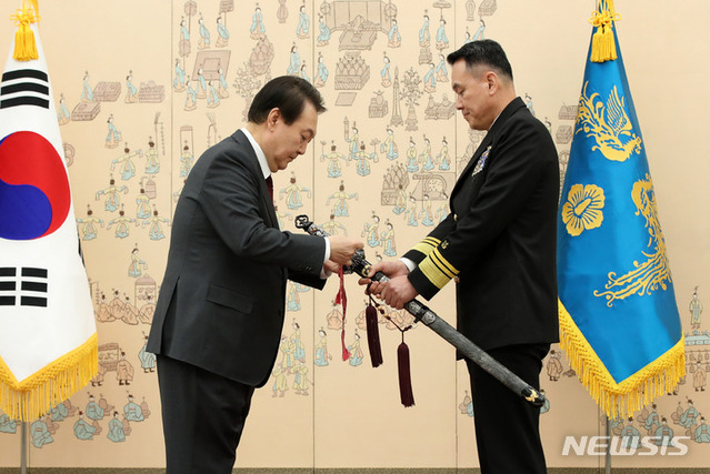 ▲ 윤석열 대통령이 7일 서울 용산 대통령실 청사에서 열린 장성 보직 신고 및 삼정검 수치 수여식에서 김명수 해군작전사령관의 삼정검에 수치를 달아주고 있다. ⓒ뉴시스