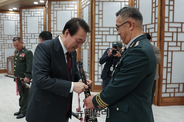 ▲ 윤석열 대통령이 7일 오전 서울 용산 대통령실에서 군 중장 18명으로부터 보직 신고를 받고 삼정검 수치(끈으로 된 깃발) 수여를 하고 있다.ⓒ대통령실 제공