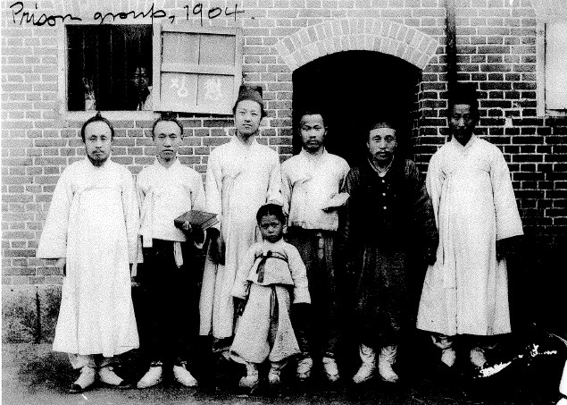 ▲ 이승만의 한성감옥 성경공부 그룹의 일부, 성경을 들고 찍었다. 왼쪽부터 세번째가 이승만, 그 앞에 어린이는 이승만의 아들 봉수. 나막신을 신었다. 사진 왼쪽위 영문자는 이승만이 뒷날 써놓은 메모. ⓒ연세대이승만연구원.