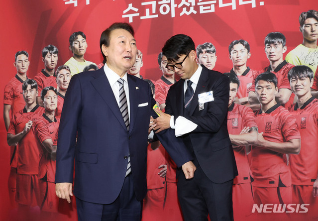 ▲ 윤석열 대통령이 8일 청와대 영빈관에서 열린 카타르 월드컵 축구 국가대표팀 환영 만찬에 앞서 카타르 월드컵 축구 국가대표팀 주장 손흥민 선수로부터 명예 캡틴 완장을 받고 있다. ⓒ뉴시스