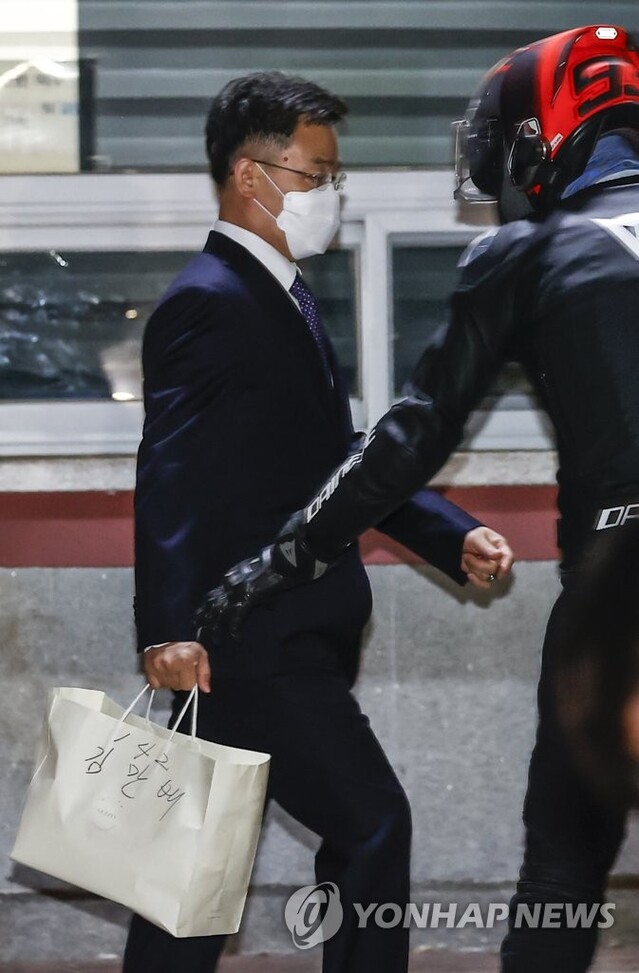 ▲ 대장동 개발 로비·특혜 의혹의 핵심 인물인 화천대유자산관리(화천대유) 대주주 김만배 씨가 지난해 10월15일 경기도 의왕 서울구치소를 나서며 헬멧을 쓰고 마중나온 쓴 최우향 씨의 도움을 받고 있다. ⓒ연합뉴스