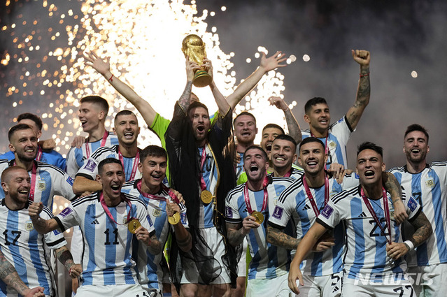 ▲ 아르헨티나의 리오넬 메시가 18일(현지시간) 카타르 루사일 스타디움에서 열린 2022 카타르 월드컵 정상에 올라 우승컵을 들고 동료들과 기념사진을 찍으며 환호하고 있다. 아르헨티나는 연장 3-3 무승부 끝에 승부차기로 프랑스를 4-2로 꺾고 36년 만에 정상에 올랐다. ⓒ루사일=AP/뉴시스