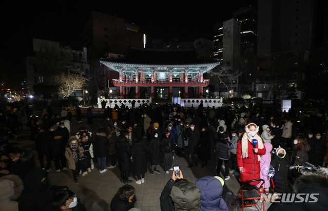 ▲ 코로나19 확산 우려로 타종 행사를 온라인으로 진행하기로 한 올해 1월1일 새벽 서울 종로구 보신각 앞에서 시민들이 새해를 맞이하고 있다. ⓒ뉴시스