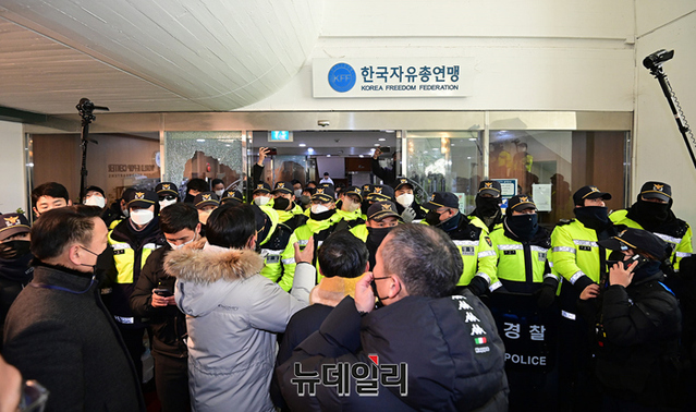 ▲ 송영무 한국자유총연맹 총재를 비롯한 수뇌부의 직무와 관련해 자총 내부 갈등을 겪고 있는 22일 오전 서울 중구 한국자유총연맹 본부 출입구에서 임시총회 공고문을 전달하기 위한 회원들과 경찰들의 대치가 이어지고 있다. ⓒ정상윤 기자