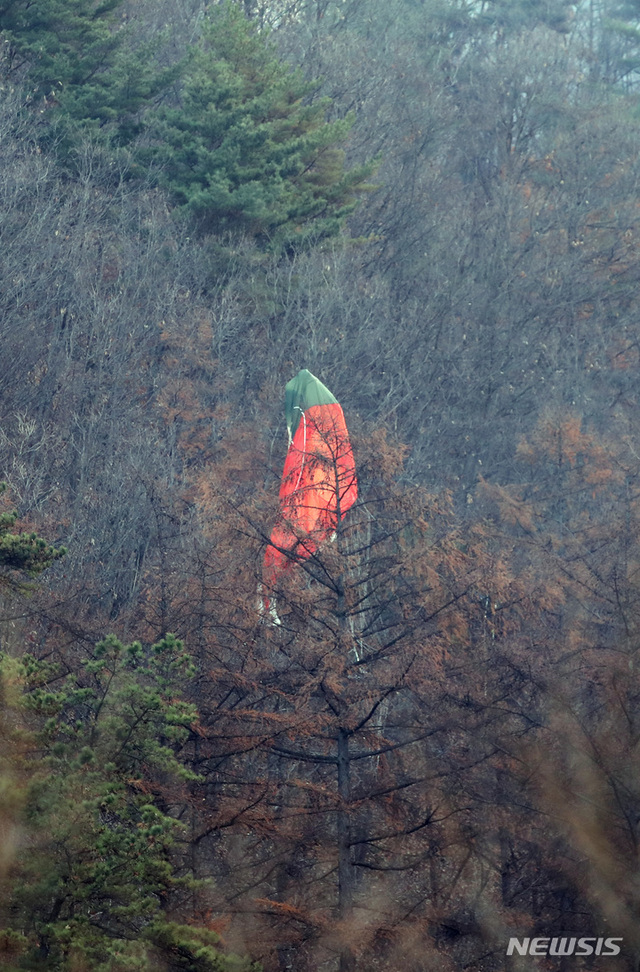 ▲ 지난 달 21일 오전 경기 양평군 양동면 금왕리 인근 야산에 추락한 'KF-16' 조종사가 탈출할 때 사용한 낙하산이 걸려 있다. ⓒ뉴시스