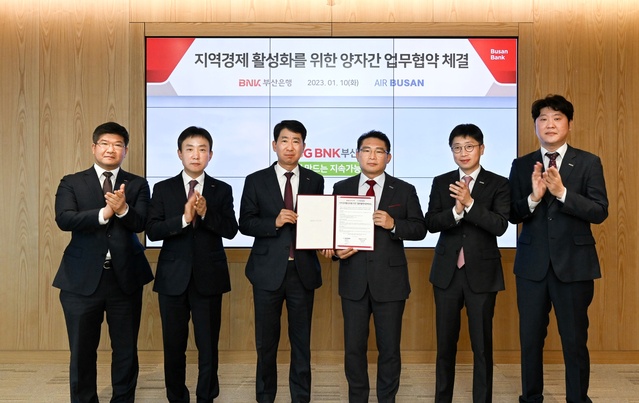 ▲ 지난 10일 부산은행 본점에서 열린 업무협약식에서 마호진(왼쪽 네 번째) 에어부산 영업본부장과 정영준(왼쪽 세 번째) 부산은행 고객지원그룹장이 업무협약을 체결하고 기념촬영을 하고 있다. ⓒ에어부산