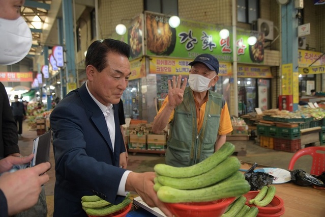 ▲ 백성현 논산시장이 지난해 전통시장 장보는날에 오이를 구입하고 있다.ⓒ논산시