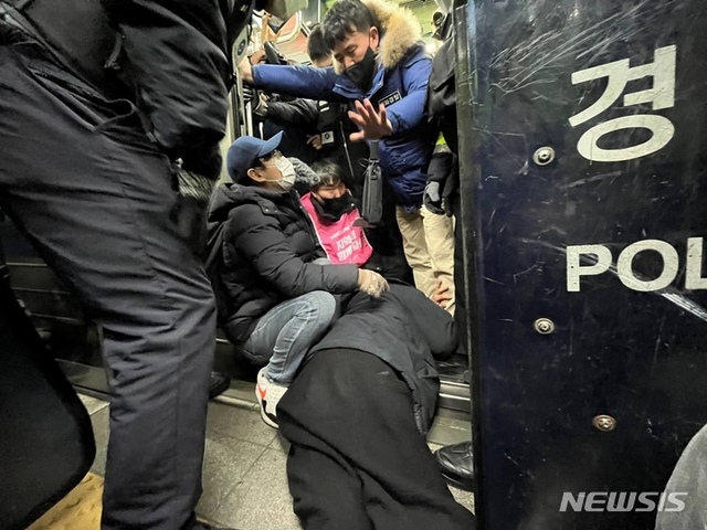 ▲ 박경석 전국장애인차별철폐연대 대표가 20일 지하철 4호선 삼각지역(숙대입구역 방향) 승강장에서 휠체어에서 내려와 기어서 승차를 시도하고 있다. ⓒ뉴시스