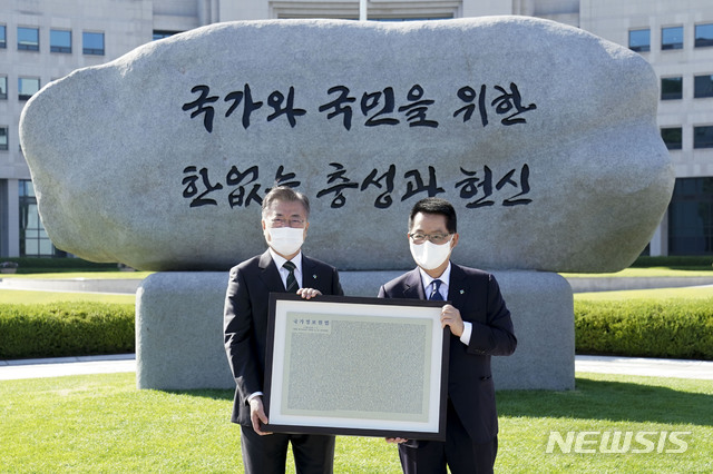 ▲ 지난 2021년 6월 4일 당시 문재인 대통령이 국가정보원에서 원훈석을 제막을 마친 후 박지원 국가정보원장에게 개정된 국정원법을 새긴 동판을 증정받고 있다. ⓒ뉴시스