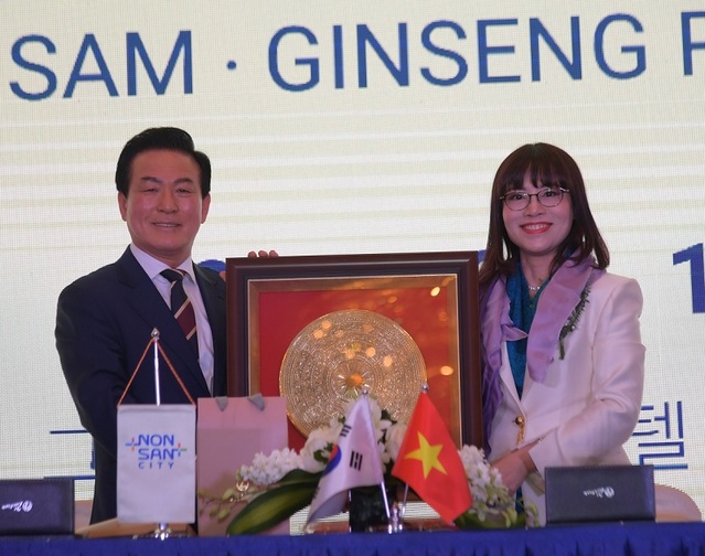 ▲ 백성현 논산시장(왼쪽)이 지난 15일 베트남 하노이 그랜드 플라자에서 응우옌 티 민항 MH그룹 대표와  기념품 전달한 뒤 기념촬영을 하고 있다.ⓒ논산시