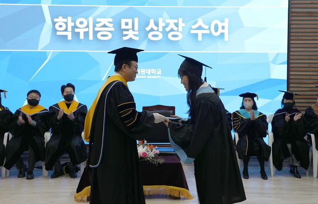 ▲ 손석민 총장이 16일 2022학년도 전기학위수여식에서 한 졸업생에게 상을 주고 있다.ⓒ서원대