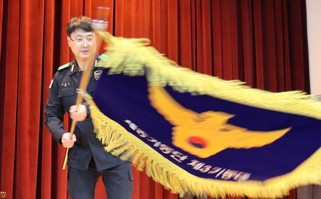 ▲ 23일 정부세종청사경비대 다목적 체육관에서 열린 '세종경찰청 제3기동대' 창설식에서 한 대원이 창설기를 흔들고 있디.ⓒ세종경찰청