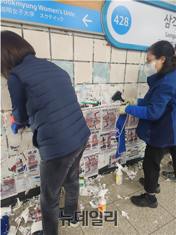 ▲ 서울교통공사가 27일 오전 서울지하철 4호선 삼각지역에서 전국장애인차별철폐연대가 부착한 시위 스티커를 제거하고 있다. ⓒ안선진 기자