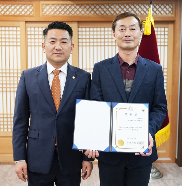 ▲ 서훈 충남 논산시의회 의장(왼쪽)이 지난 7일 김영중 의회운영전문위원 5급 승진 인사를 단행하고 기념촬영을 하고 있다.ⓒ논산시의회