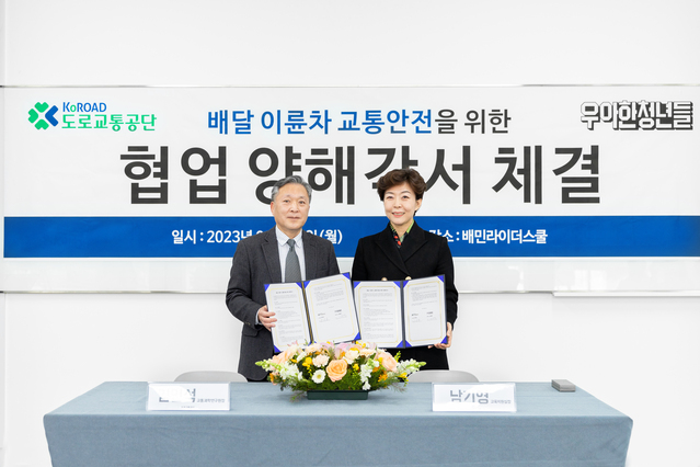 ▲ 남기영 우아한청년들 교육지원실장(오른쪽)과 김인석 도로교통공단 교통과학연구원장(왼쪽)이 지난 13일  경기도 남양주시에 위치한 배민라이더스쿨에서 ‘배달 이륜차 교통안전을 위한 양해각서’를 체결한 후 기념 촬영을 하고 있다. ⓒ우아한청년들