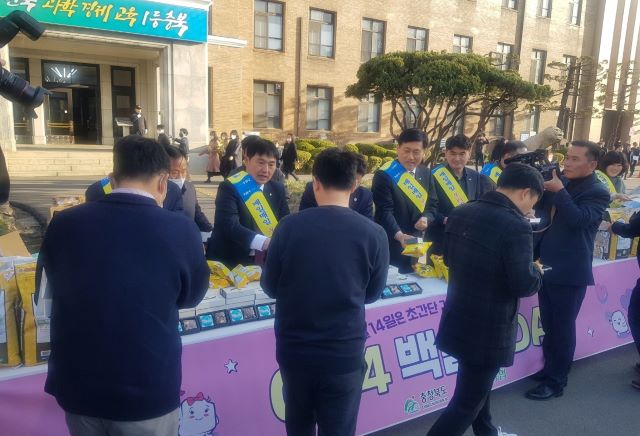 ▲ 이정표 충북농협 본부장과 황종연 NH농협은행 충북본부장이 14일 충북도청 정문 앞에서 이우종 부지사, 이제승 충북도 농정국장 등 관계자들과 백설기 떡을 나눠주고 있다.ⓒ충북농협