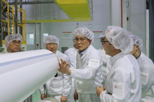 SK아이이테크놀로지 김철중 사장(가운데)이 지난 14일 중국 창저우시에 위치한 SK아이이테크놀로지 중국 생산공장을 방문해 관계자들과 생산 시설을 둘러 보고 있다. ⓒSKIET 제공