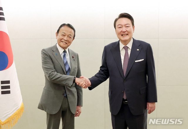 ▲ 윤석열 대통령이 17일 도쿄 시내 한 호텔에서 열린 일한협력위원회 접견에서 일본 자민당 부총재인 아소 다로 전 총리와 악수하고 있다. ⓒ뉴시