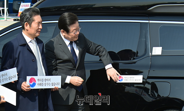 ▲ 이재명 더불어민주당 대표가 22일 국회 본청 앞에서 열린 대일굴종외교 규탄 태극기달기 운동 행사에서 자신의 차량에 '역사를 팔아서 미래를 살 수는 없습니다' 문구의 스티커를 붙이고 있다. ⓒ이종현 기자