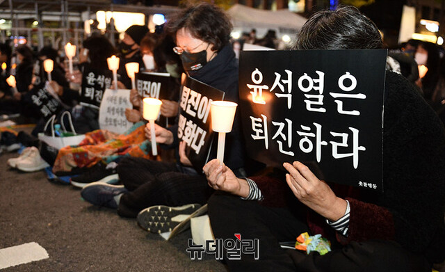 ▲ 지난해 11월 5일 서울 중구 시청역 인근에서 열린 '이태원 참사 희생자 추모 집회'에서 촛불행동 참가자들이 윤석열 대통령의 퇴진을 요구하는 손피켓을 들고 있다. ⓒ이기륭 기자