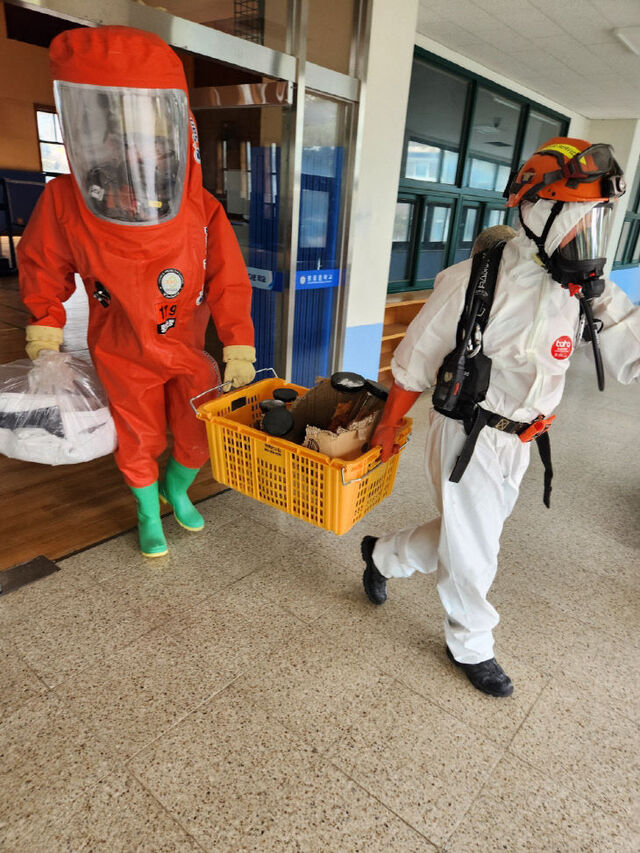 ▲ 학교에서 소방관들이 23일 천안 A 중학교에서 누출된  유독성 화학약품을 수거한 뒤 밖으로 옮기고 있다.ⓒ천안동남소방서