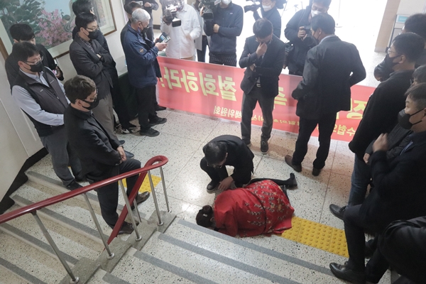 ▲ 오경나 충청대 총장이 지난달 30일 신임 총장 임명과 관련해 이사회에 참석하려 했으나 교수와 직원들에 의해 저지된 가운데 대학 본관 1층에 쓰러져 있다.ⓒ사진 충청타임즈 제공