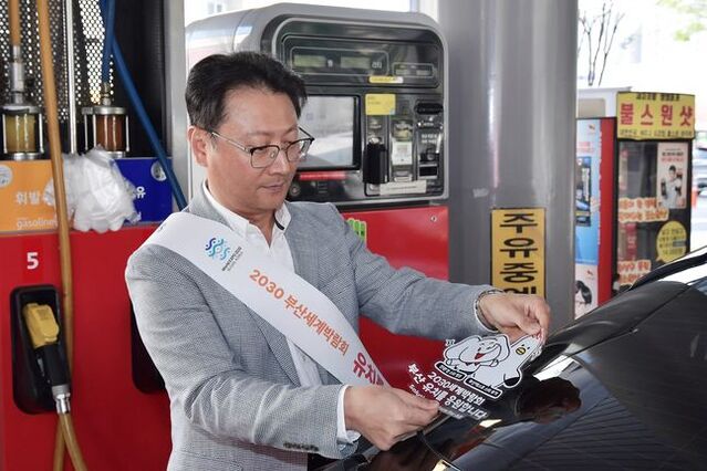 ▲ 오종훈 SK에너지 P&M CIC 대표가 부산엑스포 유치 기원 차량부착용 스티커를 부착하고 있다. ⓒSK에너지 제공