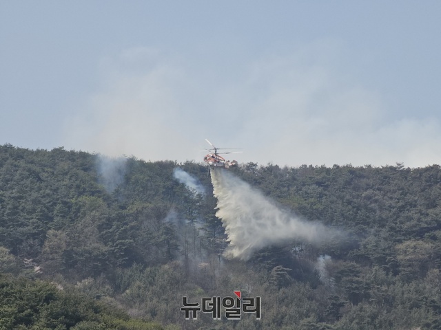 ▲ 충남 홍성군 서부면 중리에서 발생한 산불이 1000㏊의 산림과 주택 등 62채가 소실되는 등 큰 피해를 낸 가운데  사흘째 진화작업을 벌이고 있다. 사진은 산림청 헬기가 산불진화를 위해 물을 뿌리고 있다.ⓒ뉴데일리 D/B