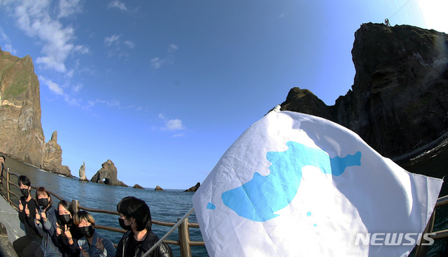 ▲ 2021년 10월 31일 '한국대학생진보연합'(대진연) 회원들이 31일 경북 울릉군 독도 선착장에서 독도가 일본 땅이라고 주장하는 일본 정부를 규탄하는 기자회견을 마치고 '한반도기'를 흔들고 있다. ⓒ뉴시스