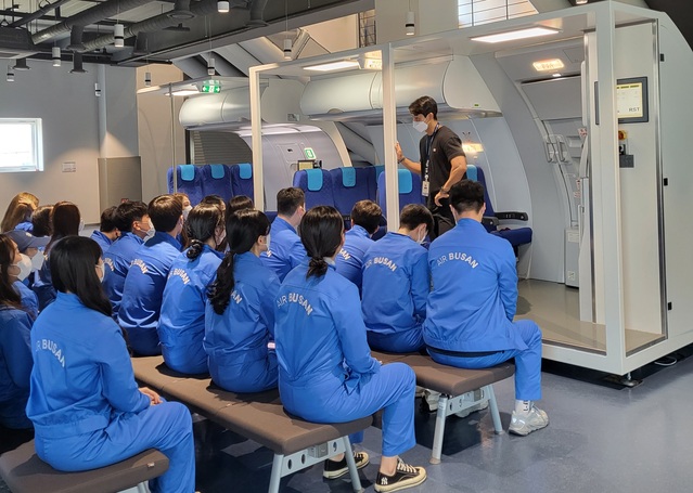 ▲ 지난해 드림 아카데미에 참여한 교육생들이 비상문 작동법 관련 교육을 받고 있다. ⓒ에어부산