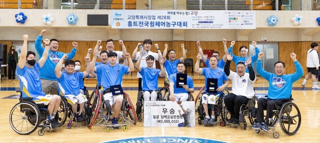 ▲ 코웨이 블루휠스 휠체어농구단이 홀트전국휠체어농구대회에서 처음으로 우승을 차지했다. 코웨이 블루휠스 선수들과 관계자들이 우승을 기뻐하며 기념촬영을 하고 있다. ⓒ코웨이