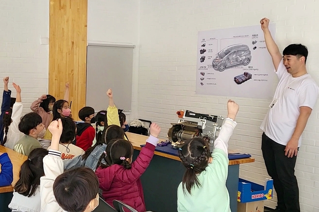 ▲ LG마그나 직원이 LG마그나가 생산한 부품을 교구로 활용해 학생들에게 전기차에 대해 설명하고 있다. ⓒLG전자