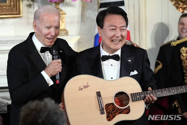 ▲ 윤석열 대통령이 지난달 26일(현지시간) 백악관에서 열린 국빈 만찬을 마친 후 조 바이든 대통령으로부터 미국 싱어송라이터 돈 맥클린의 친필 서명이 담긴 기타를 선물받고 있다. ⓒ뉴시스