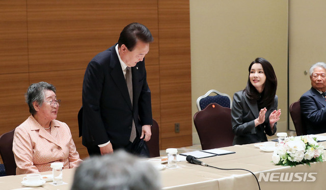 ▲ 주요7개국(G7) 정상회의 참석을 위해 일본을 방문한 윤석열 대통령이 19일 히로시마 한 호텔에서 열린 히로시마 동포 원폭 피해자와의 간담회에 앞서 박남주 한국원폭피해대책특별위 전 위원장의 착석을 도와준 뒤 박수받고 있다. ⓒ뉴시