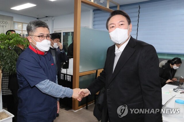 ▲ 국민의힘 윤석열 대선 후보가 2021년 12월 22일 저녁 전북 군산에서 횟집을 운영 중인 함운경 씨를 찾아 악수하고 있다. 함 씨는 지난 1985년 미국 문화원 점거 사건을 주도한 운동권 출신으로 언론을 통해 현 정부의 소득주도 성장 정책을 강하게 비판한 바 있다.ⓒ연합뉴스